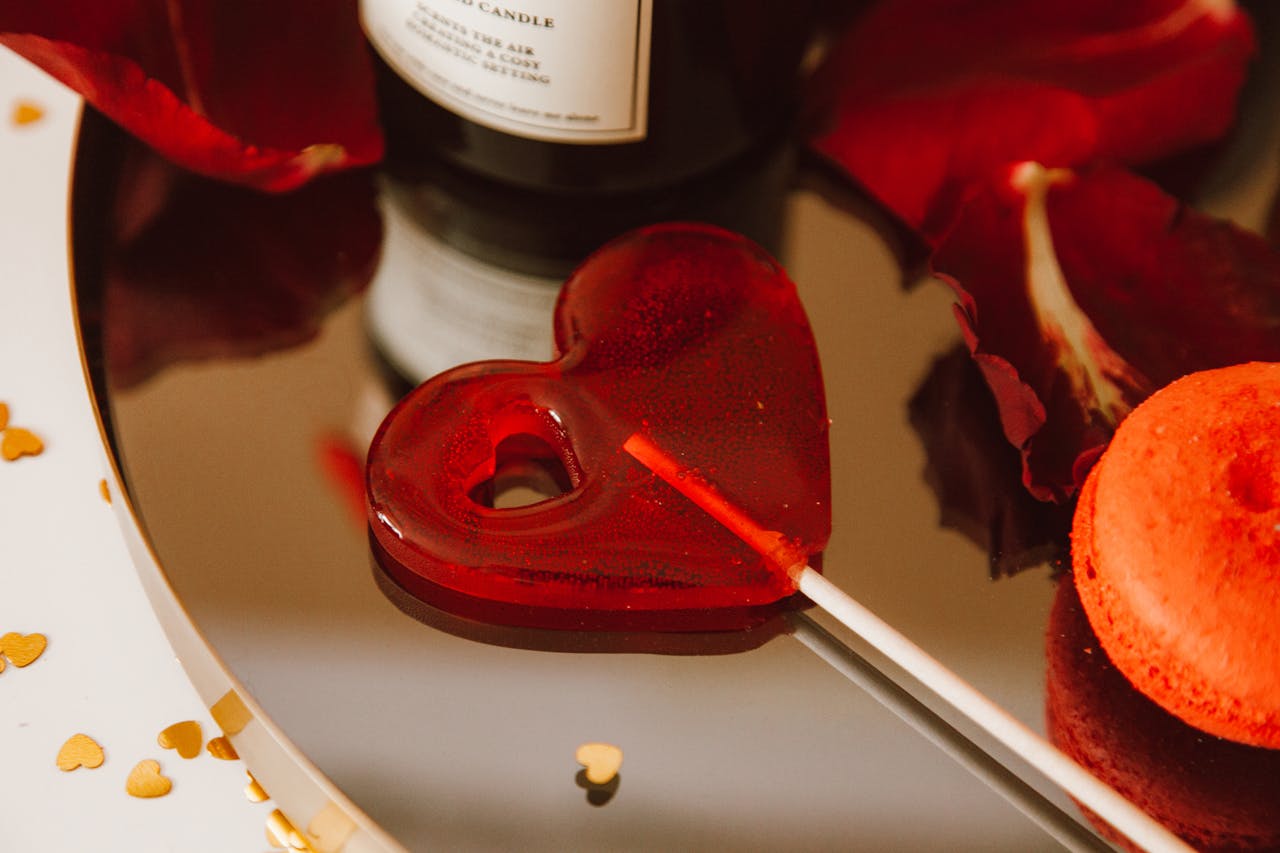 project-03-c Heart-shaped red lollipop with rose petals and gold hearts, perfect for Valentines Day themes.
